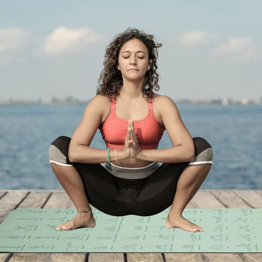 femme sur tapis yoga dans un parc face à une rivière fait un exercice de relaxation